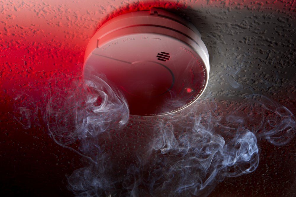 Smoke Detector Attached to a White Textured Ceiling in an Office Setting — FNQ Smoke Alarms & Maintenance in Cairns, QLD