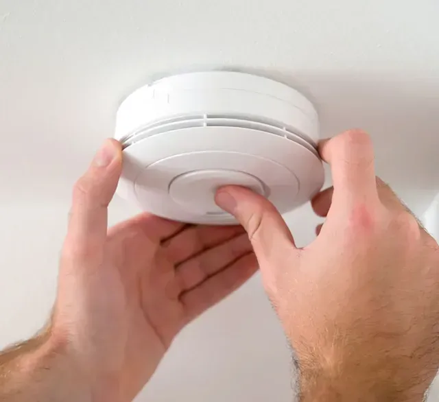 Person in a Hard Hat Inspecting Electrical Panel — FNQ Smoke Alarms & Maintenance in Yungaburra, QLD