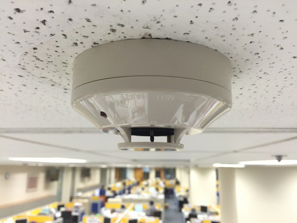 Smoke Detector on a Textured Ceiling in an Office — FNQ Smoke Alarms & Maintenance in Innisfail, QLD