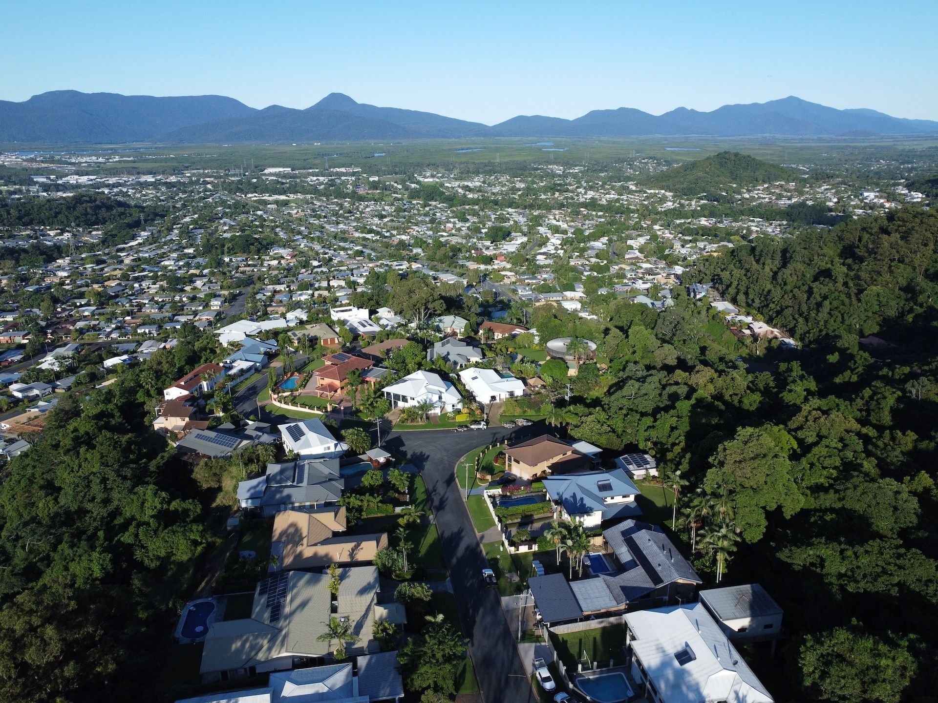 Coastal City Skyline Next to a Sandy Beach and Ocean. Cloudy Day — FNQ Smoke Alarms & Maintenance in Woree, QLD