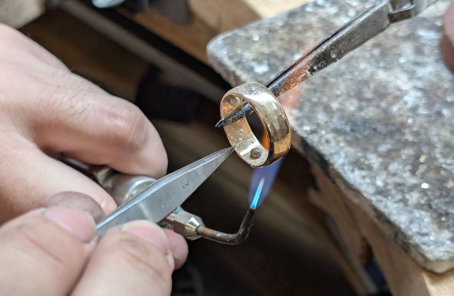 A ring with a pink stone and diamonds is sitting on a wooden surface. A ring with a pink stone and diamonds is sitting on a wooden surface.