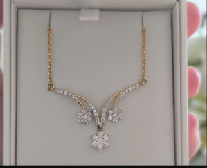 Close view of a gold necklace with diamonds in the form of three hanging flowers. Close view of a gold necklace with diamonds in the form of three hanging flowers.