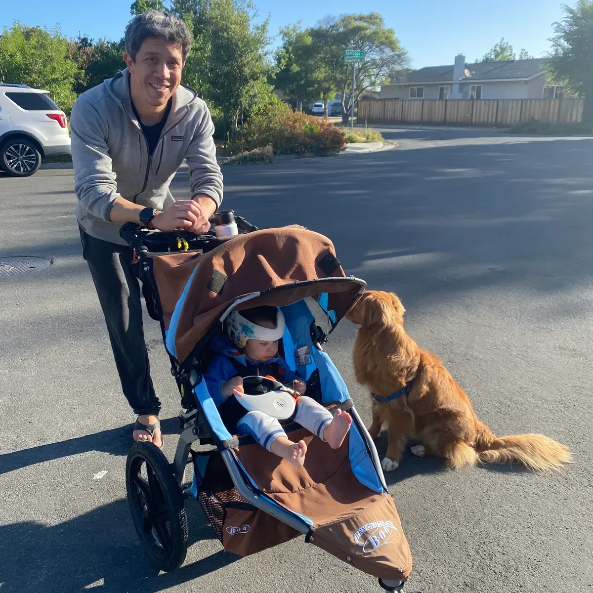 A man pushing a stroller with a baby in it