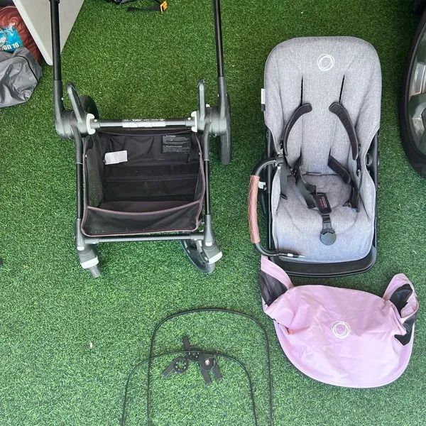 A stroller and a car seat are sitting on the grass.
