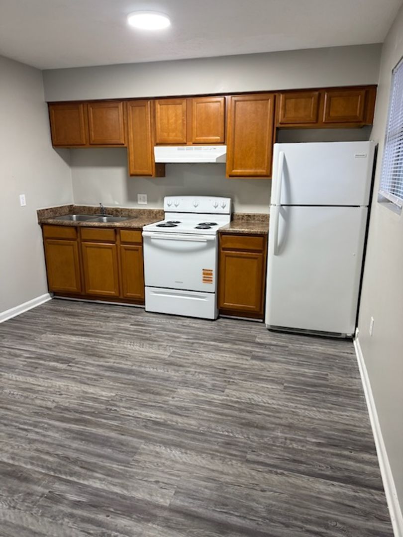 Row of brick townhouses with black shutters and doors, under a cloudy sky.