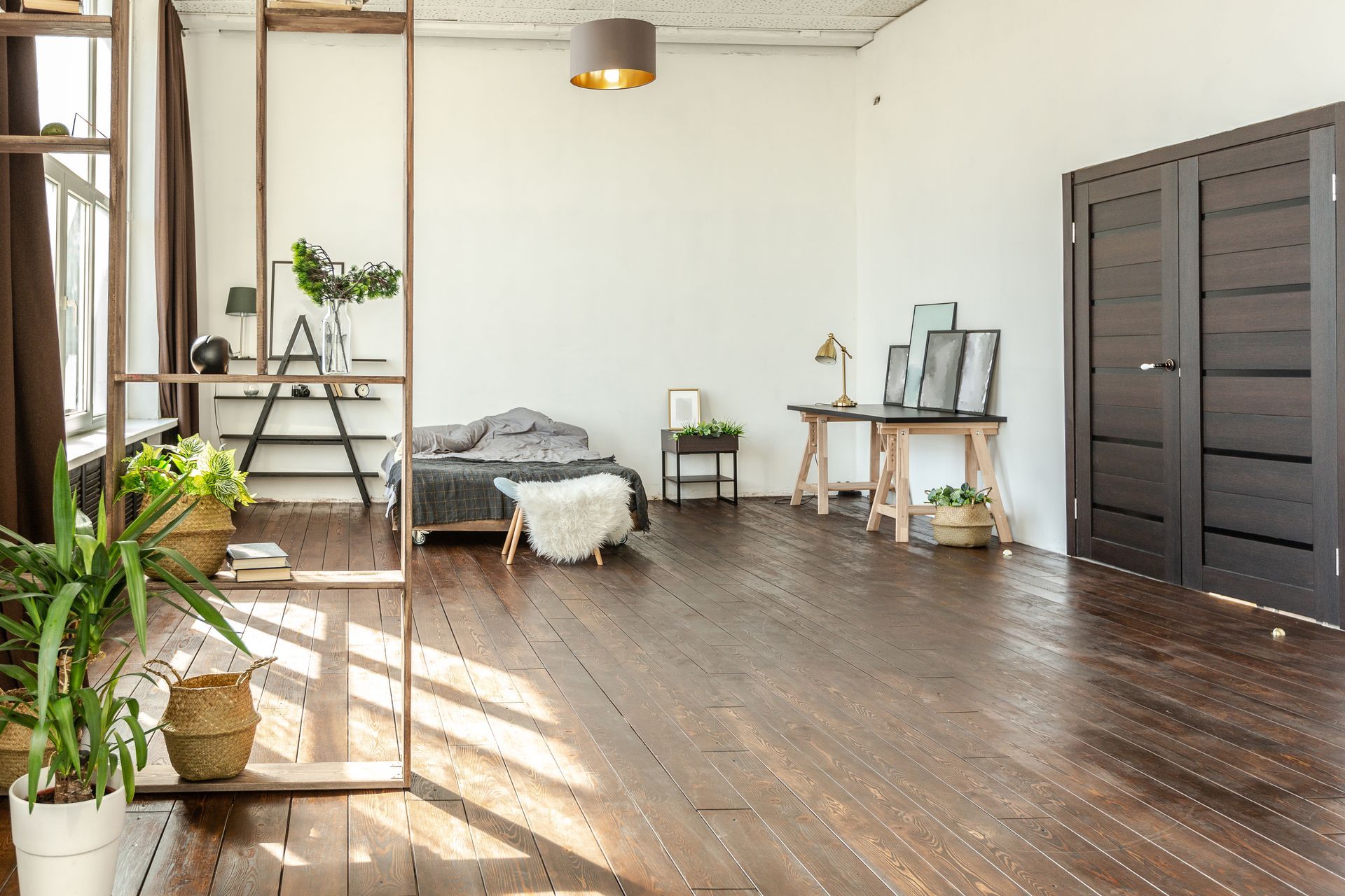 A large empty room with a wooden floor and white walls.