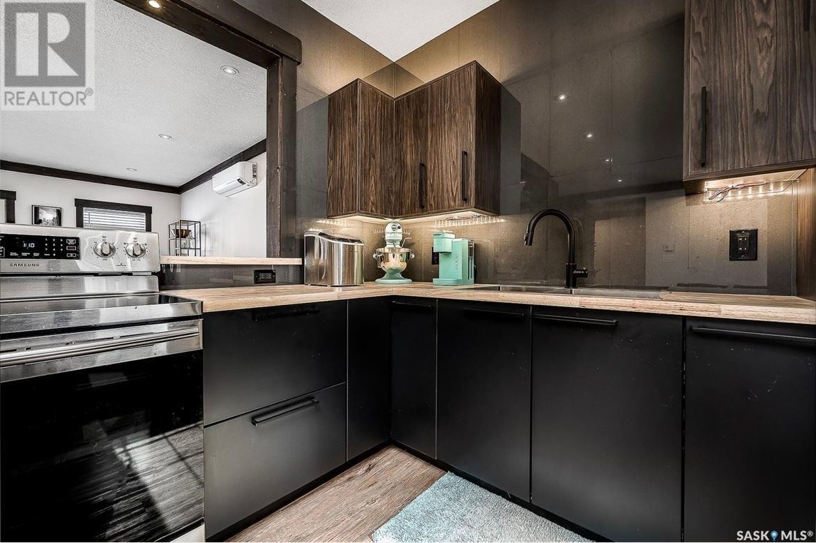 A kitchen with black cabinets and stainless steel appliances.