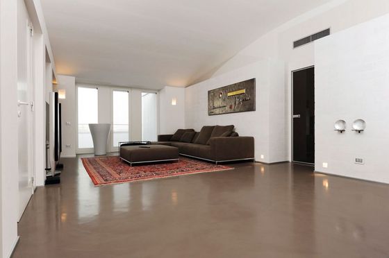 Un soggiorno con un divano marrone e un tappeto