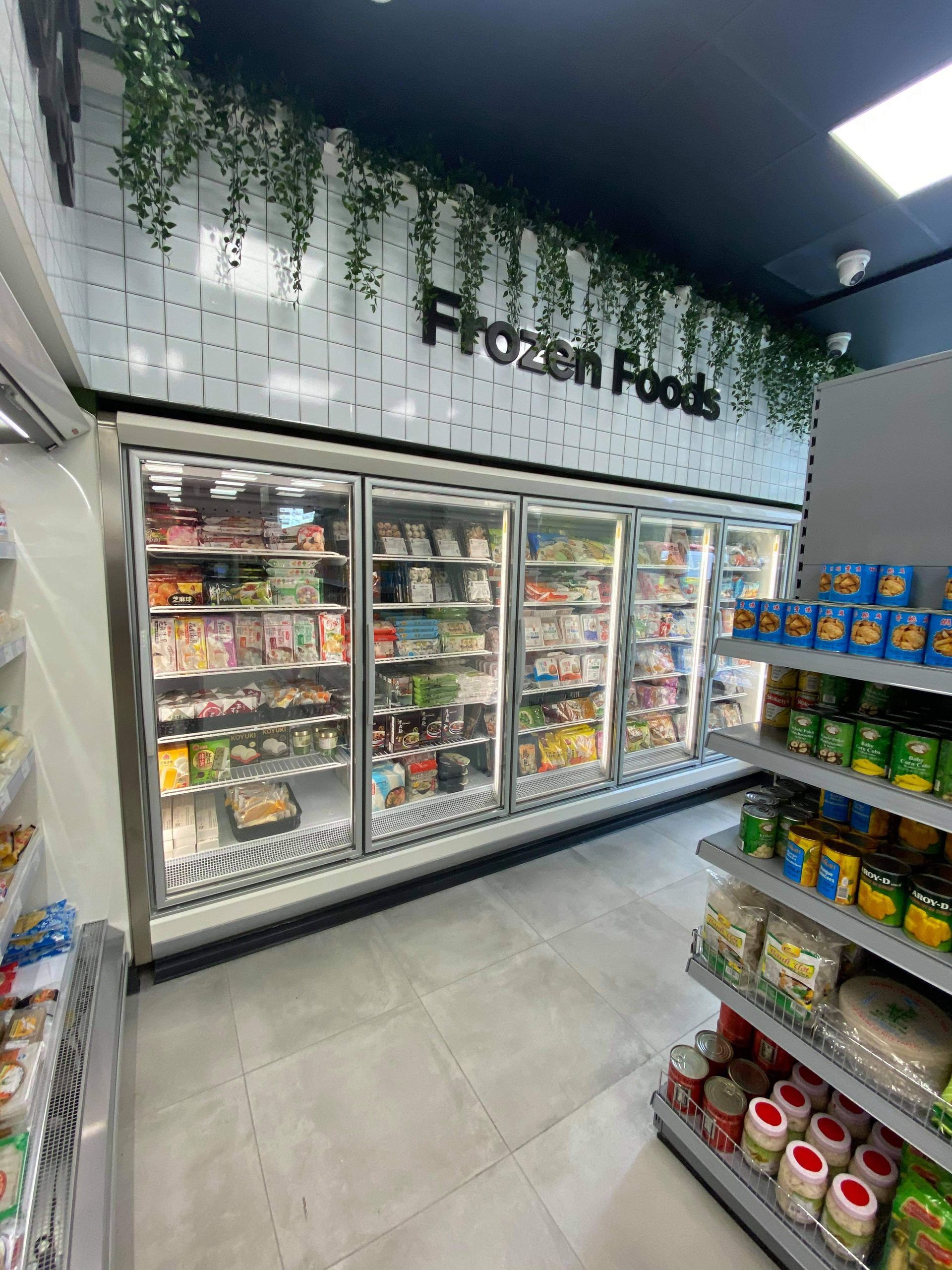 Women Selecting Product From Glass Door Multi-Deck Display Chiller