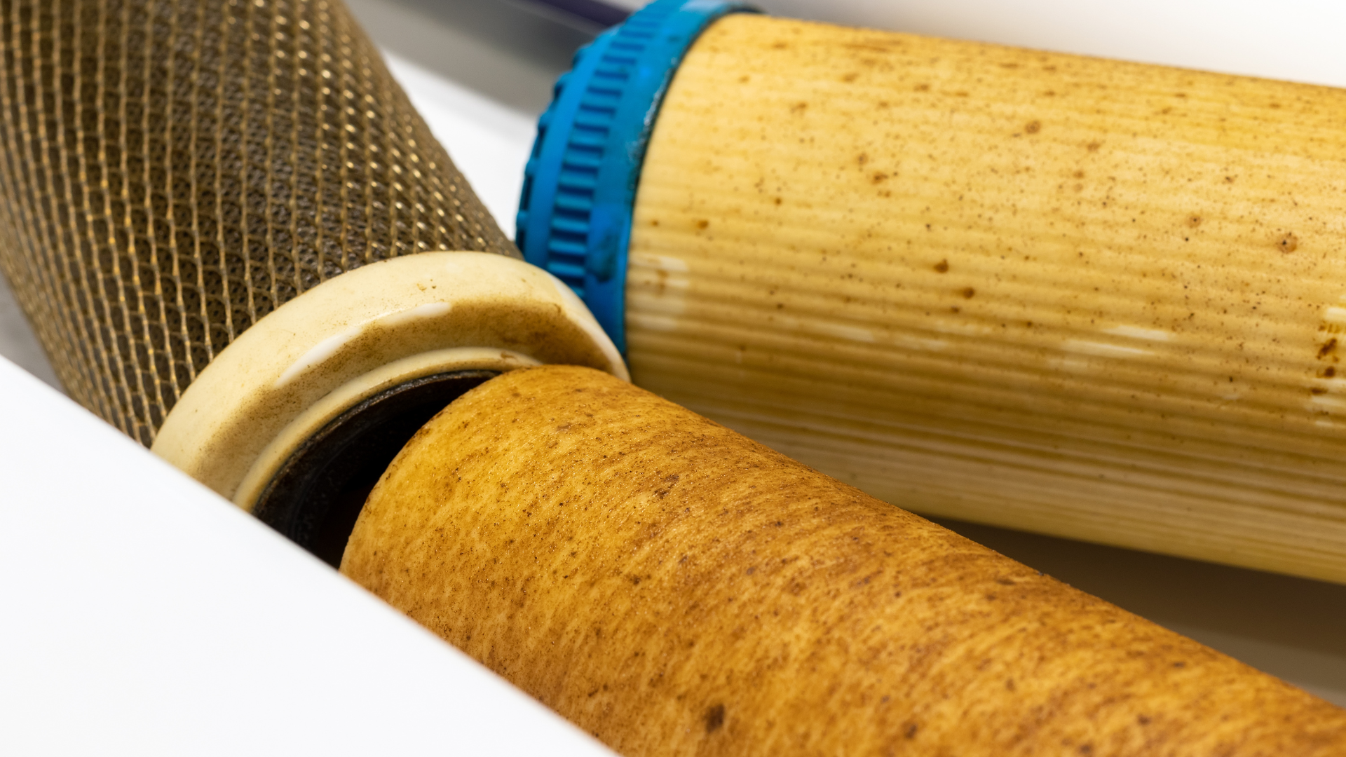 A close up of three different types of water filters on a white surface.