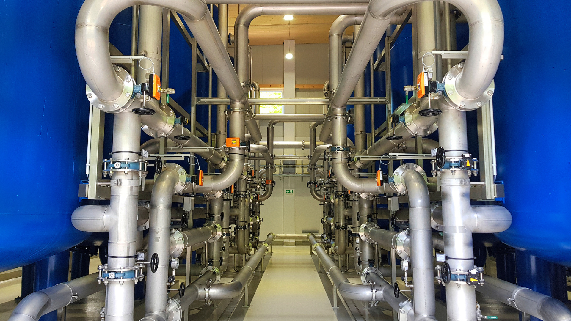 A room filled with lots of pipes and tanks in a factory.