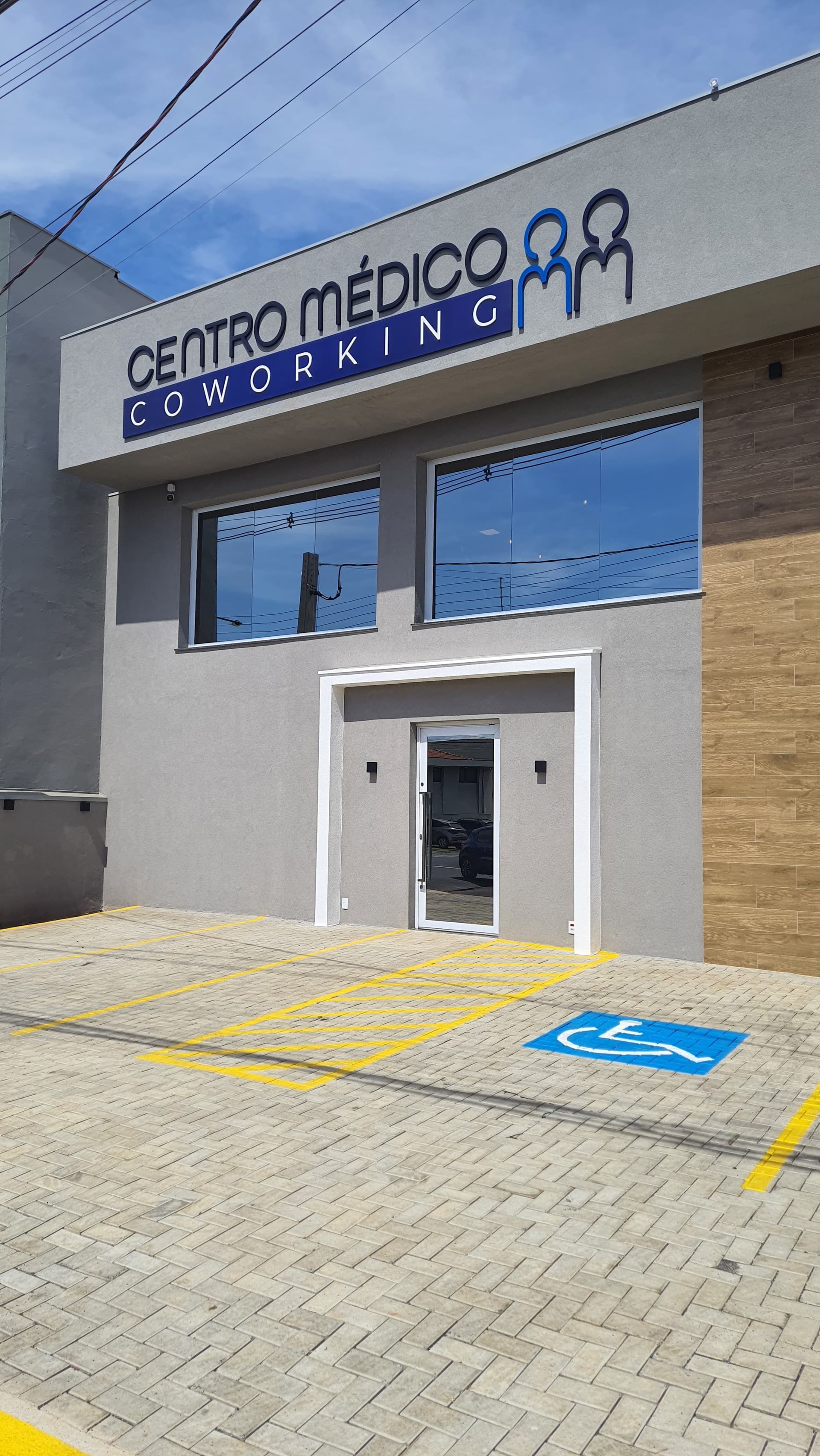 Um médico está de pé em um hospital com os braços cruzados e sorrindo.