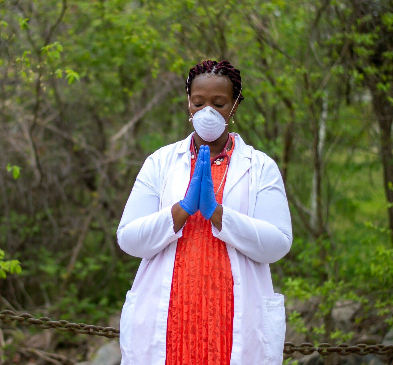 nurse Linda Gilliam-Johnson in uniform with her hands in prayer formation