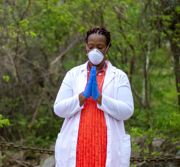 nurse Linda Gilliam-Johnson in uniform with her hands in prayer formation
