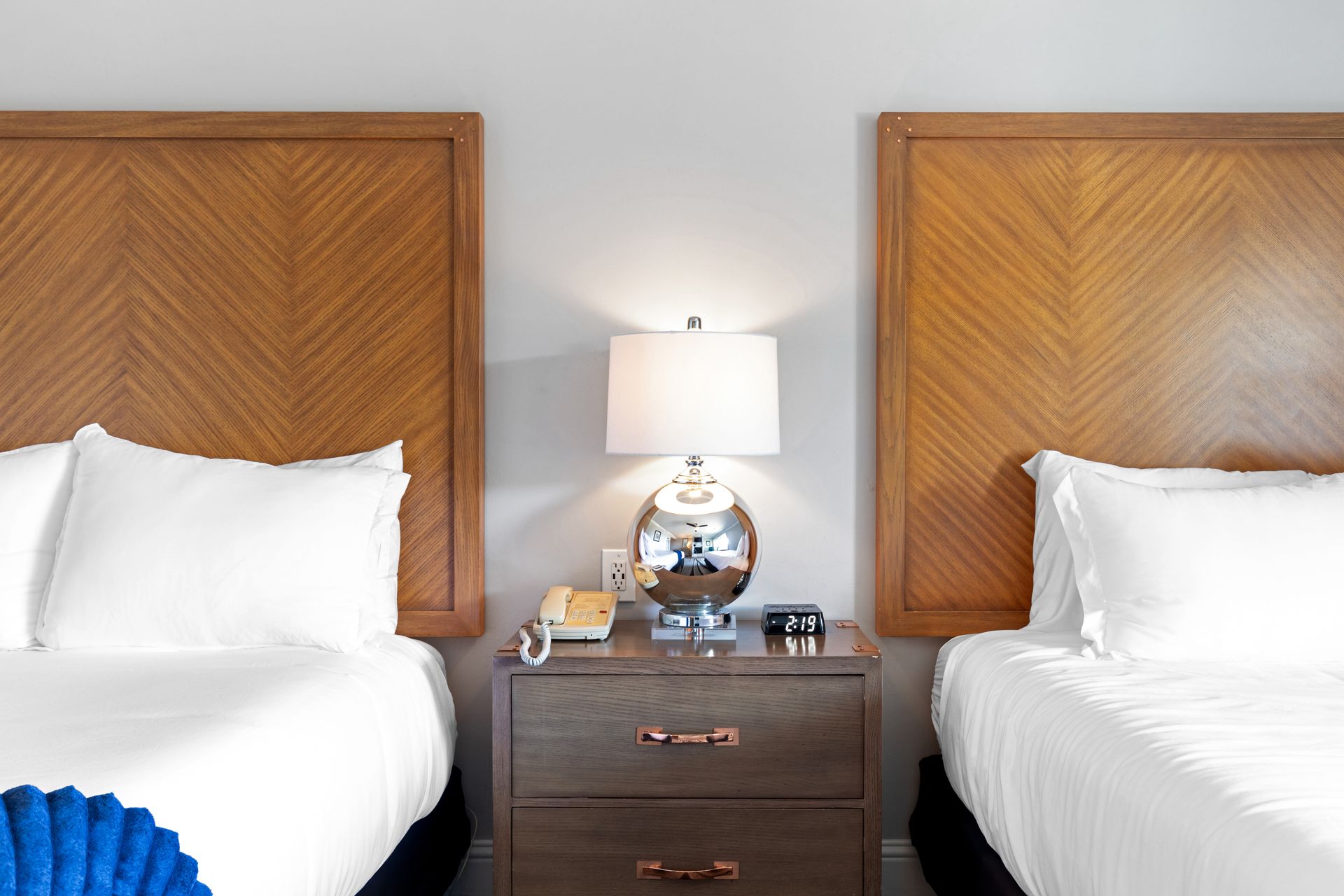 A hotel room with two beds and a nightstand