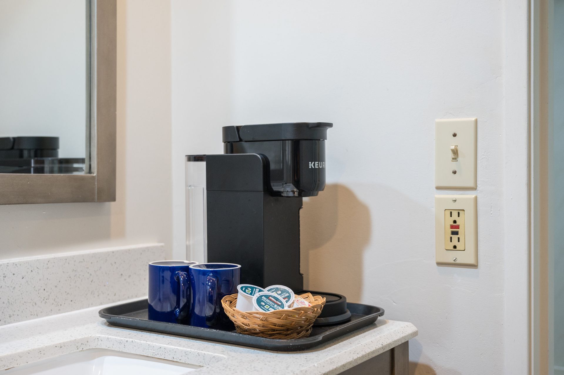 A coffee maker is sitting on a counter next to a sink.