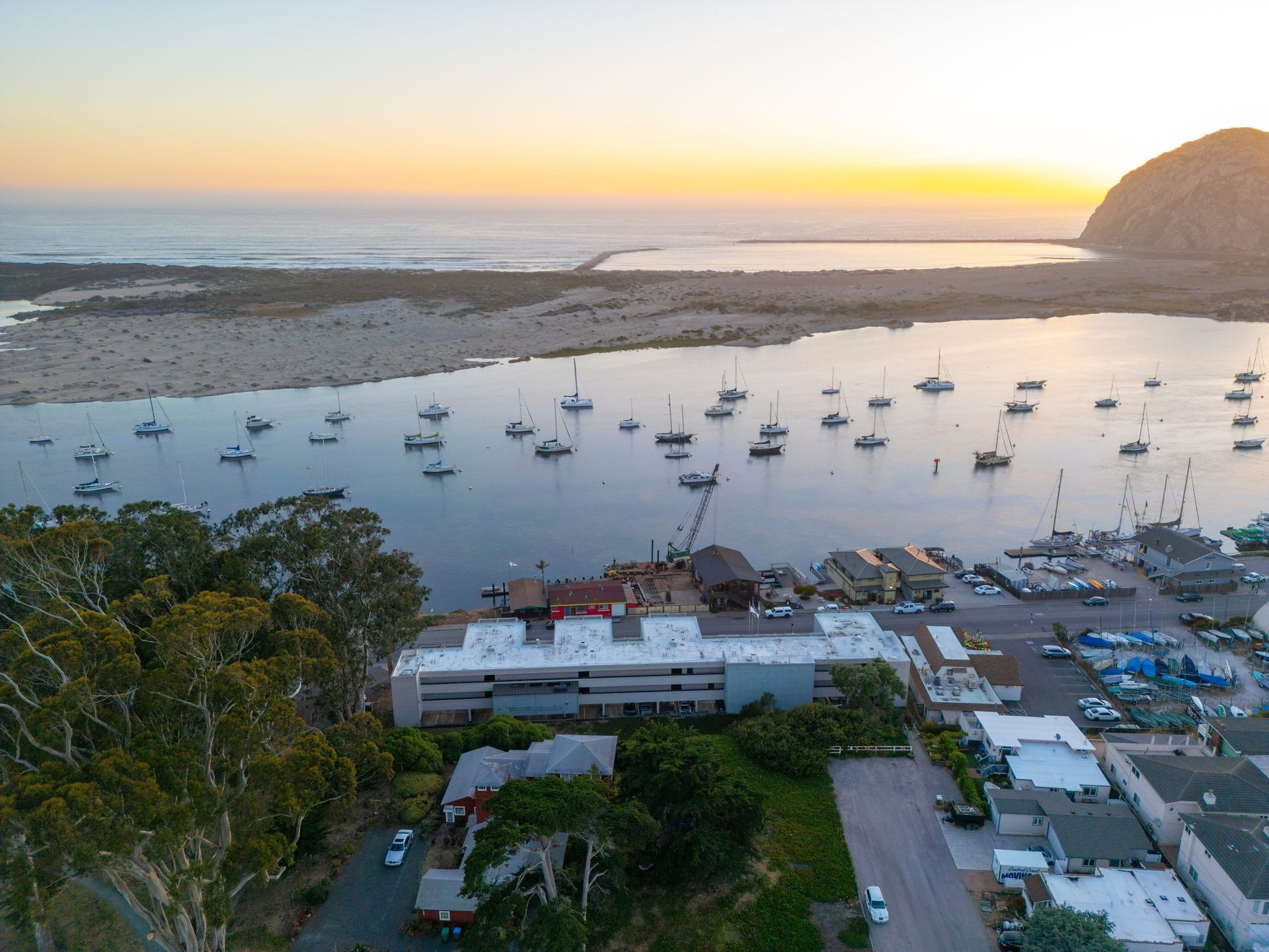 An aerial view of a harbor with boats in it at sunset.