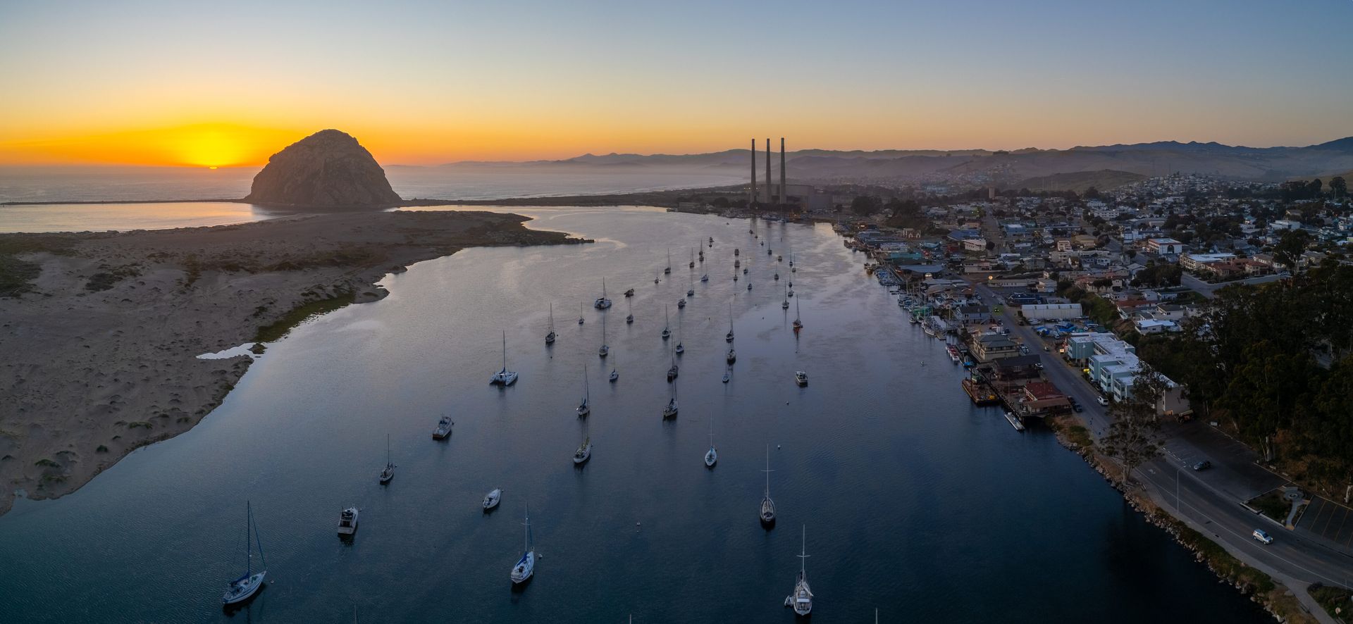An aerial view of a body of water with boats in it at sunset.