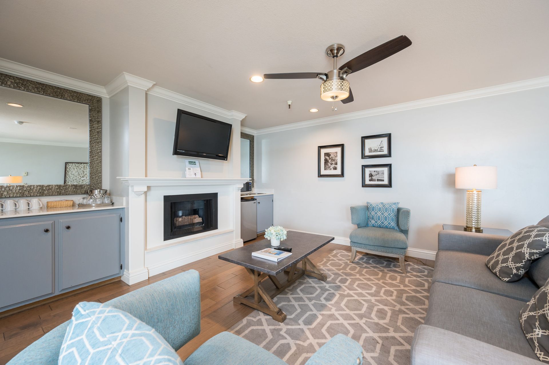 A living room with a couch , chair , coffee table , fireplace and television.