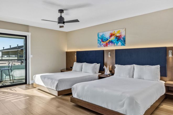 A hotel room with two beds and a ceiling fan