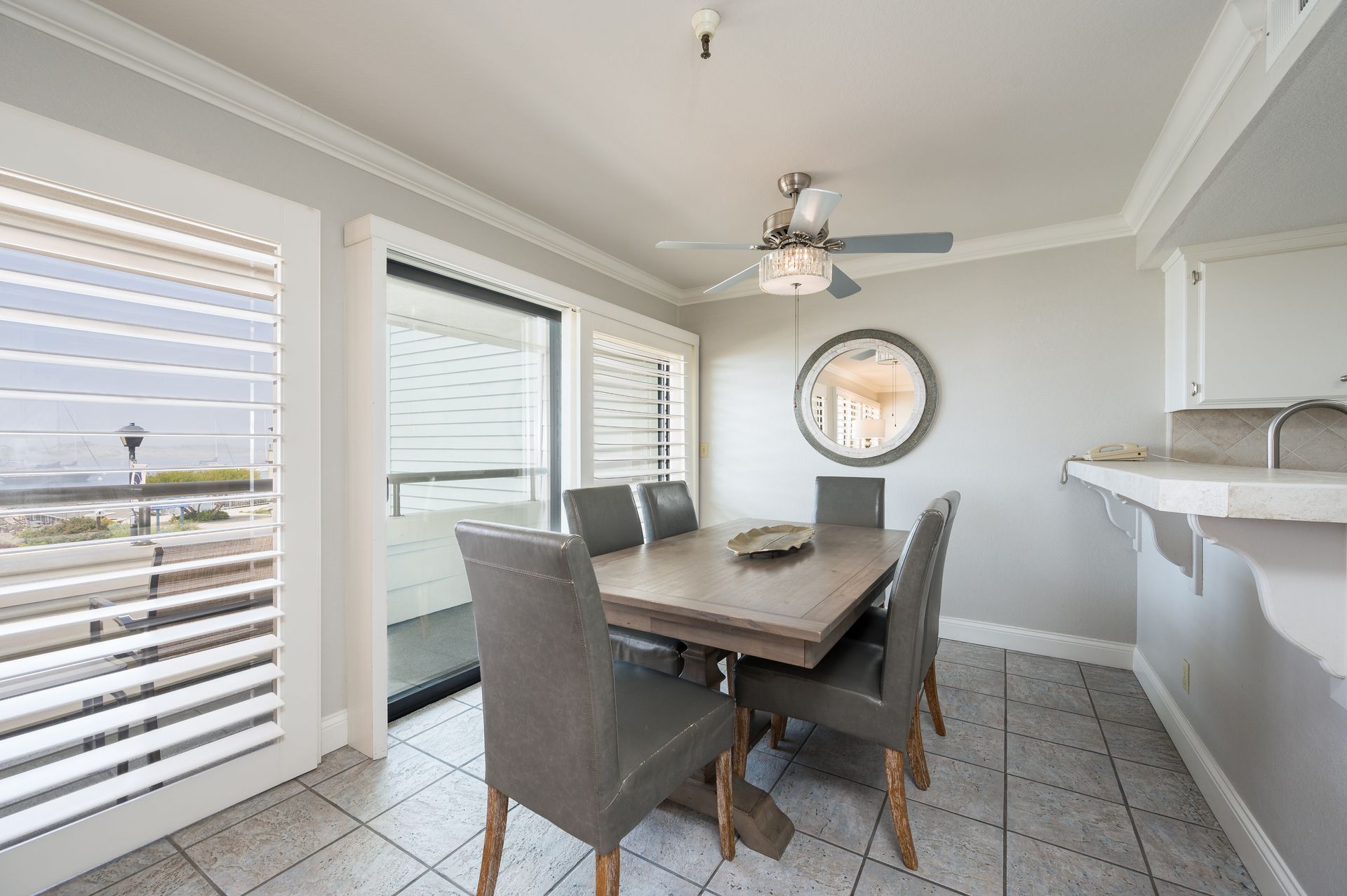 A dining room with a table and chairs and a ceiling fan.