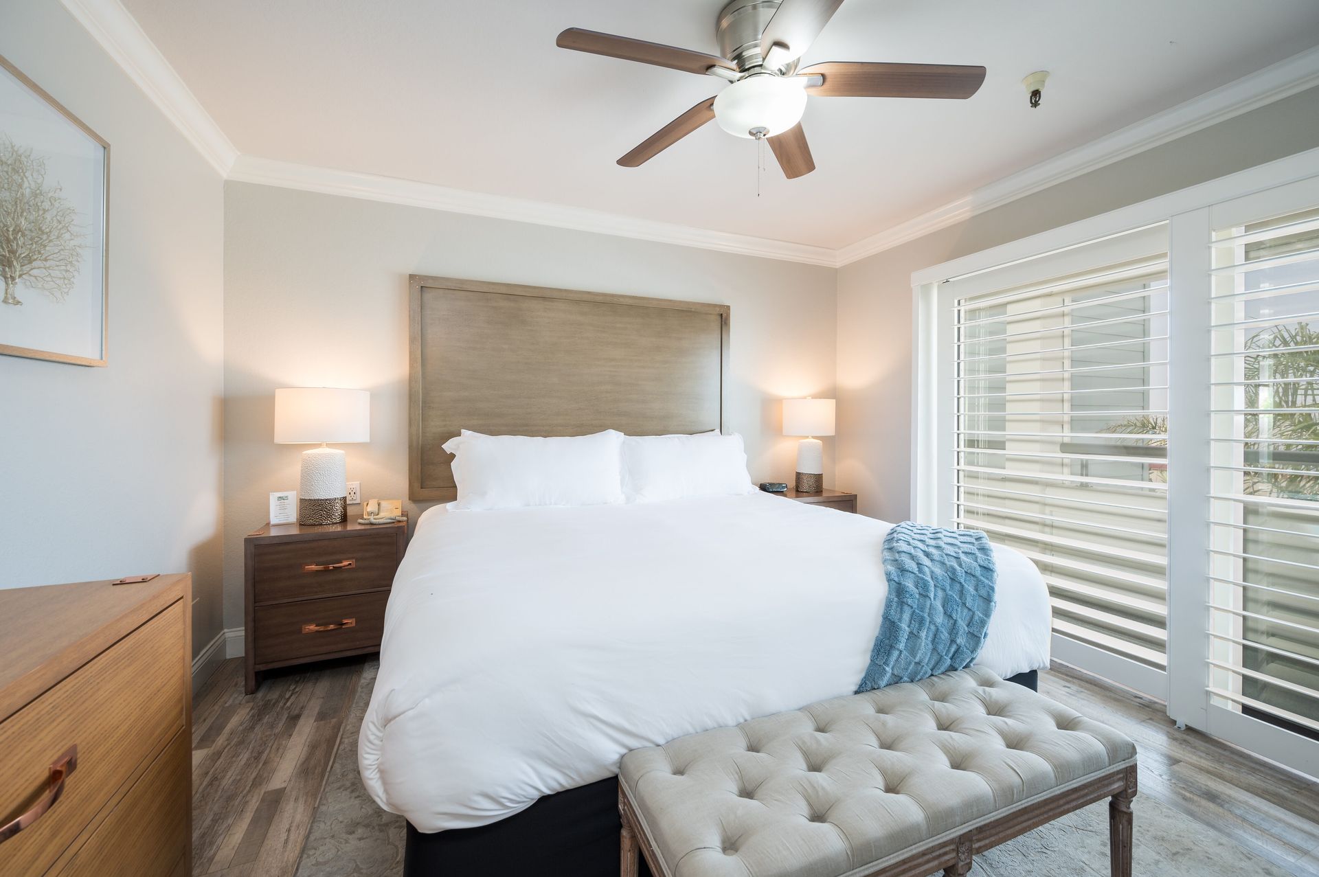 A bedroom with a large bed and a ceiling fan