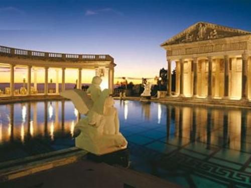 A statue in front of a building with a pool in front of it