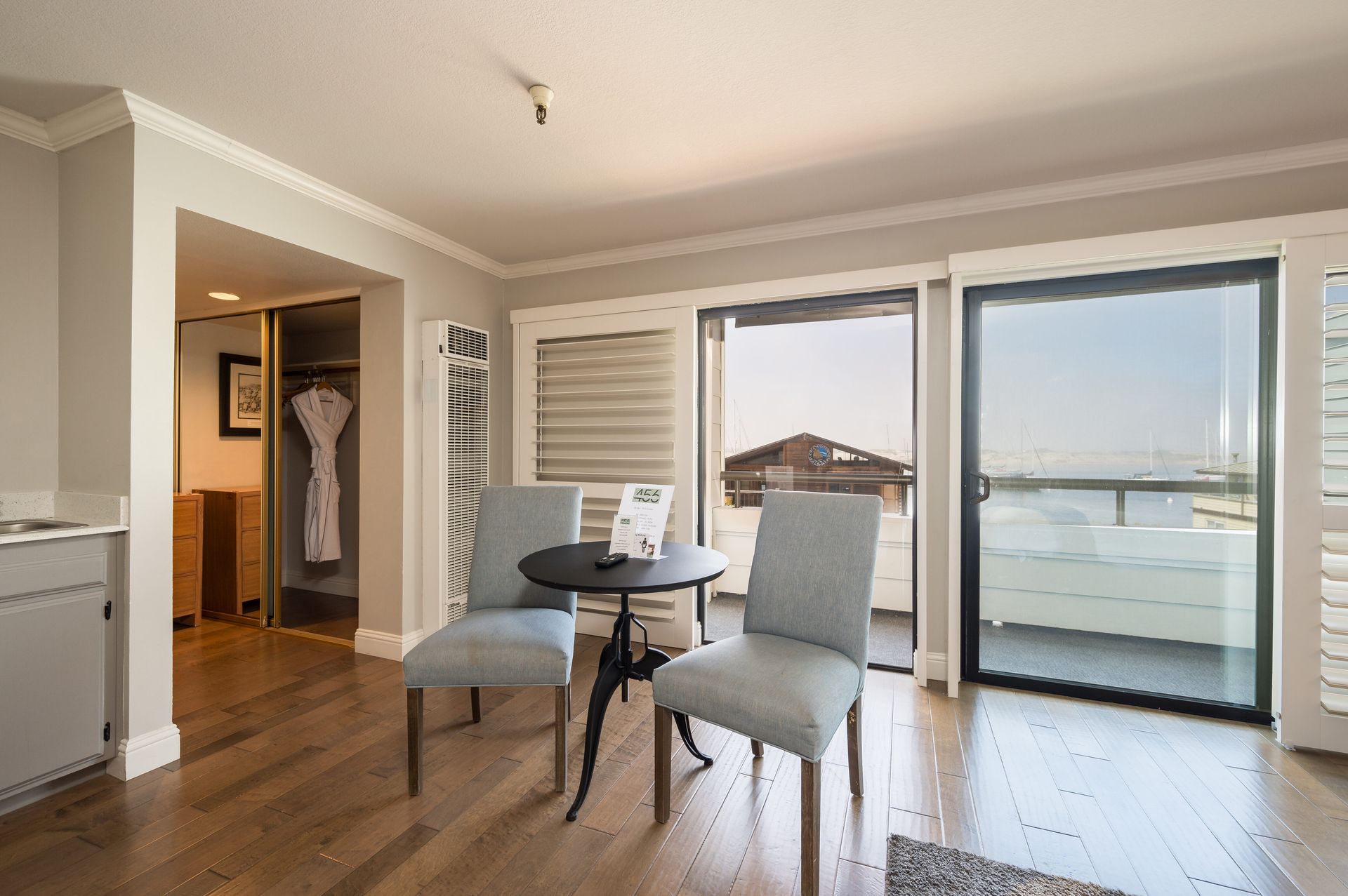 A living room with two chairs and a table with sliding glass doors.