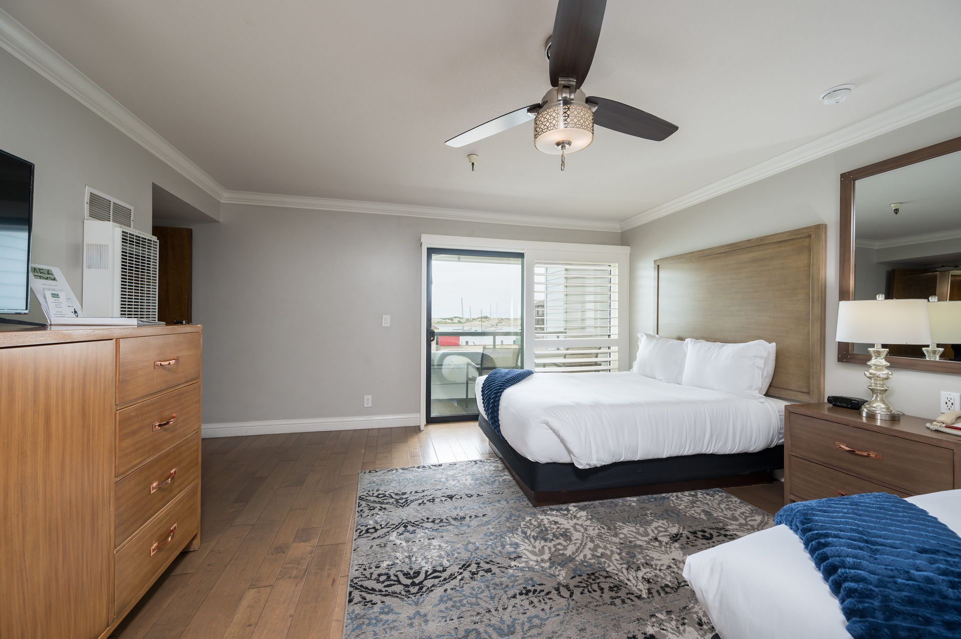 A hotel room with a large bed and a ceiling fan.