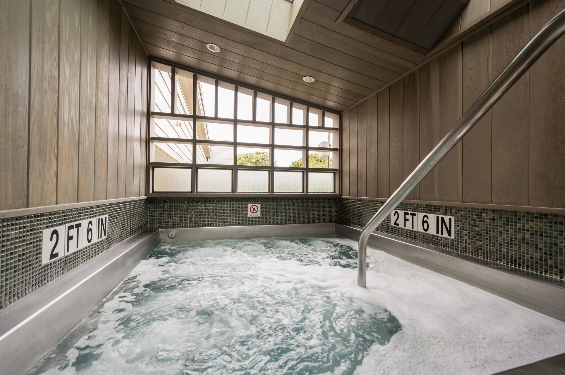 A hot tub with a staircase leading to it is filled with water.