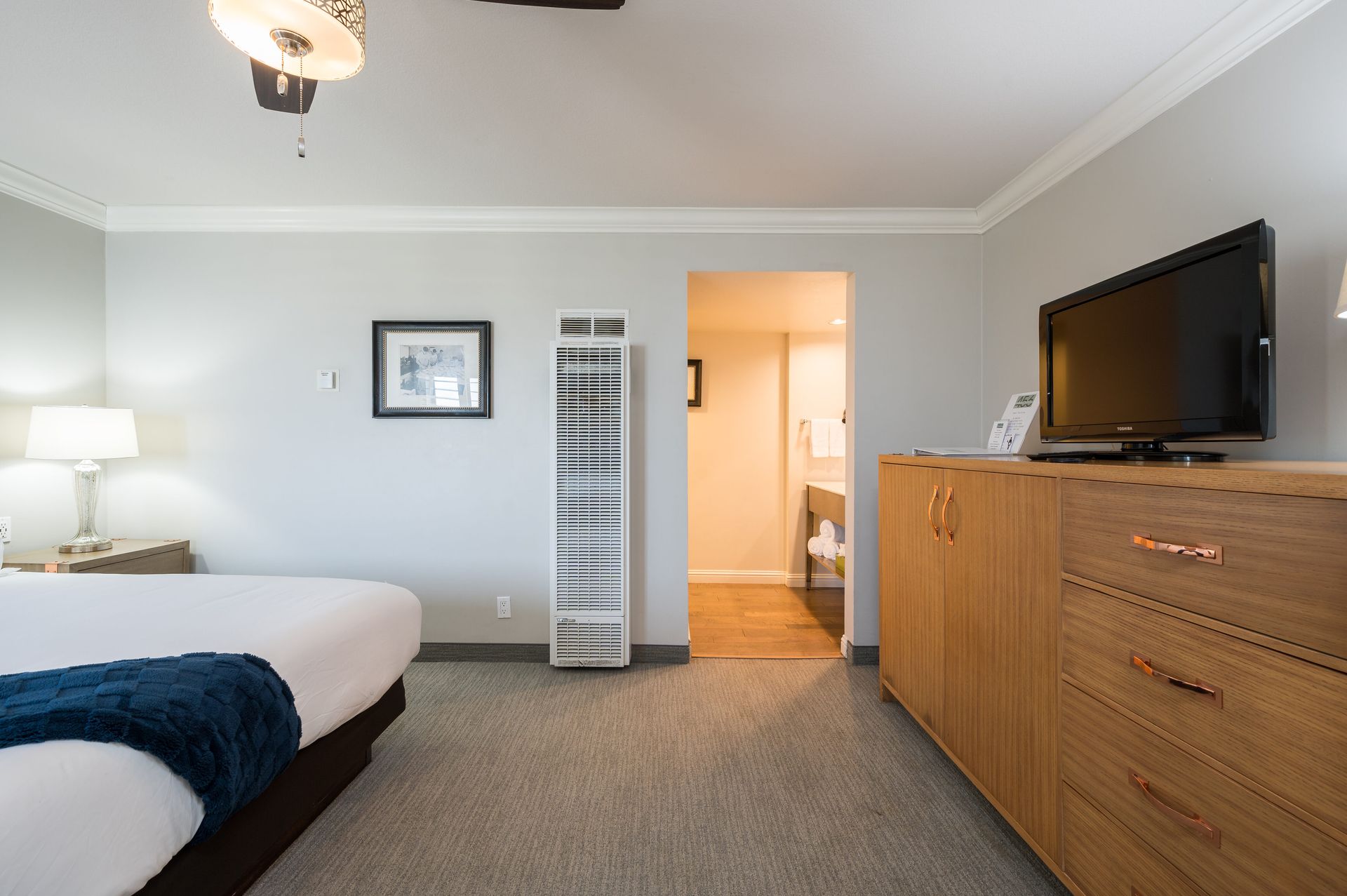 A hotel room with a king size bed and a flat screen tv.