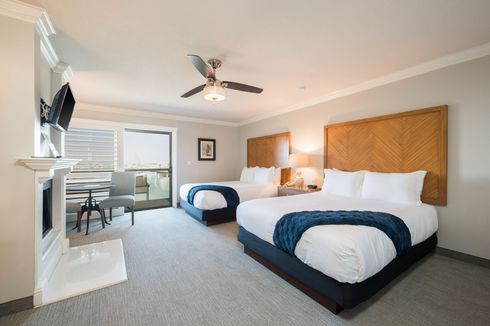 A hotel room with two beds and a ceiling fan