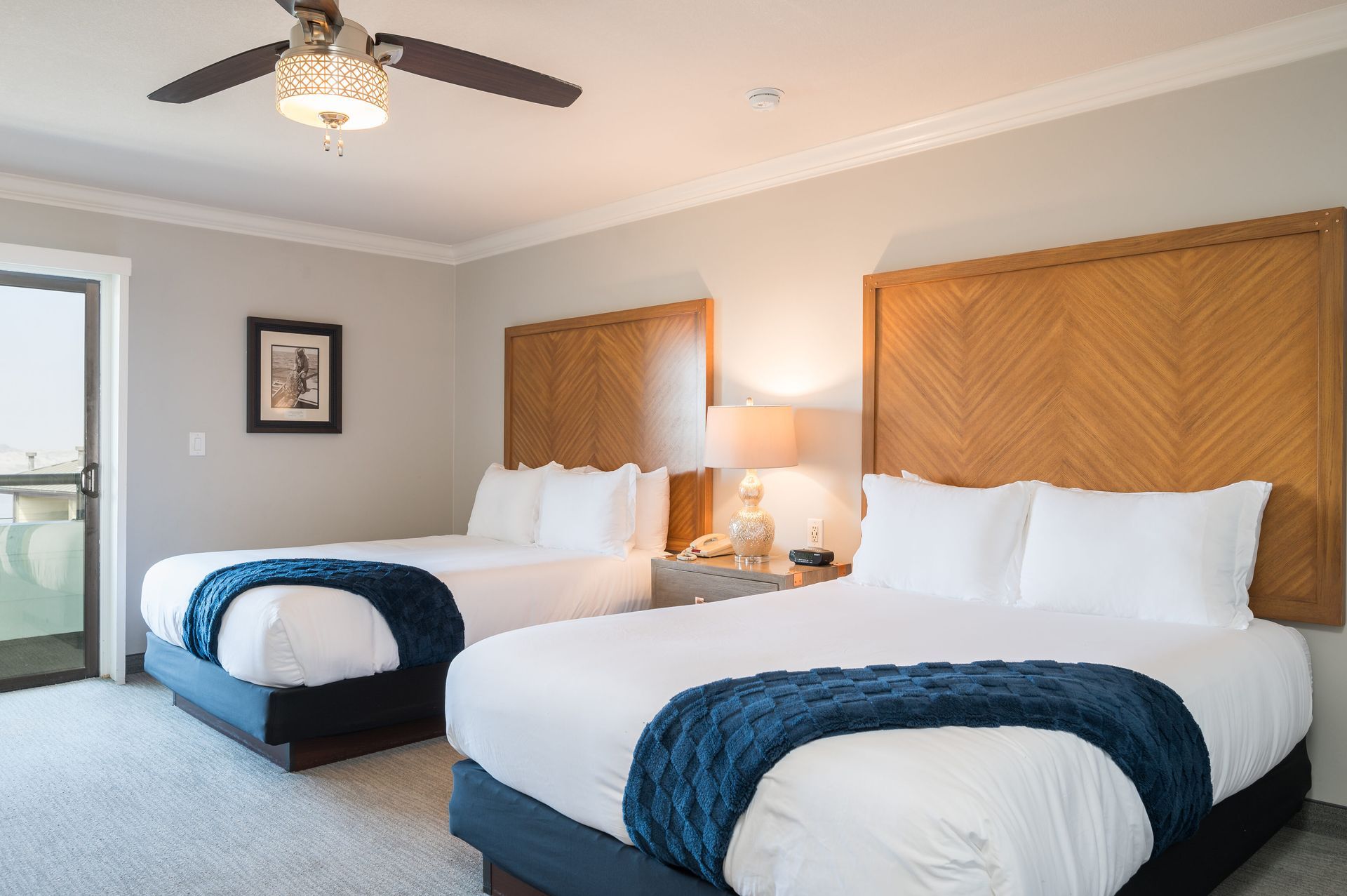 A hotel room with two beds and a ceiling fan.