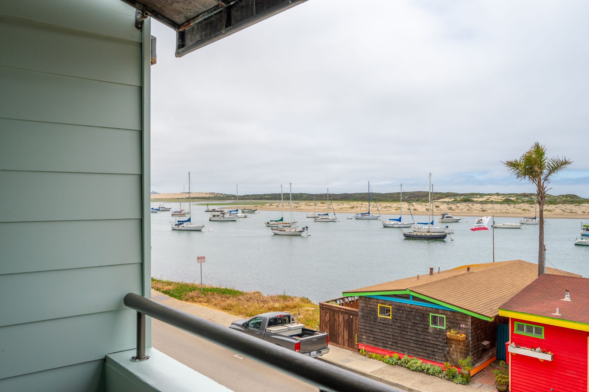 A balcony overlooking a body of water with boats in it.