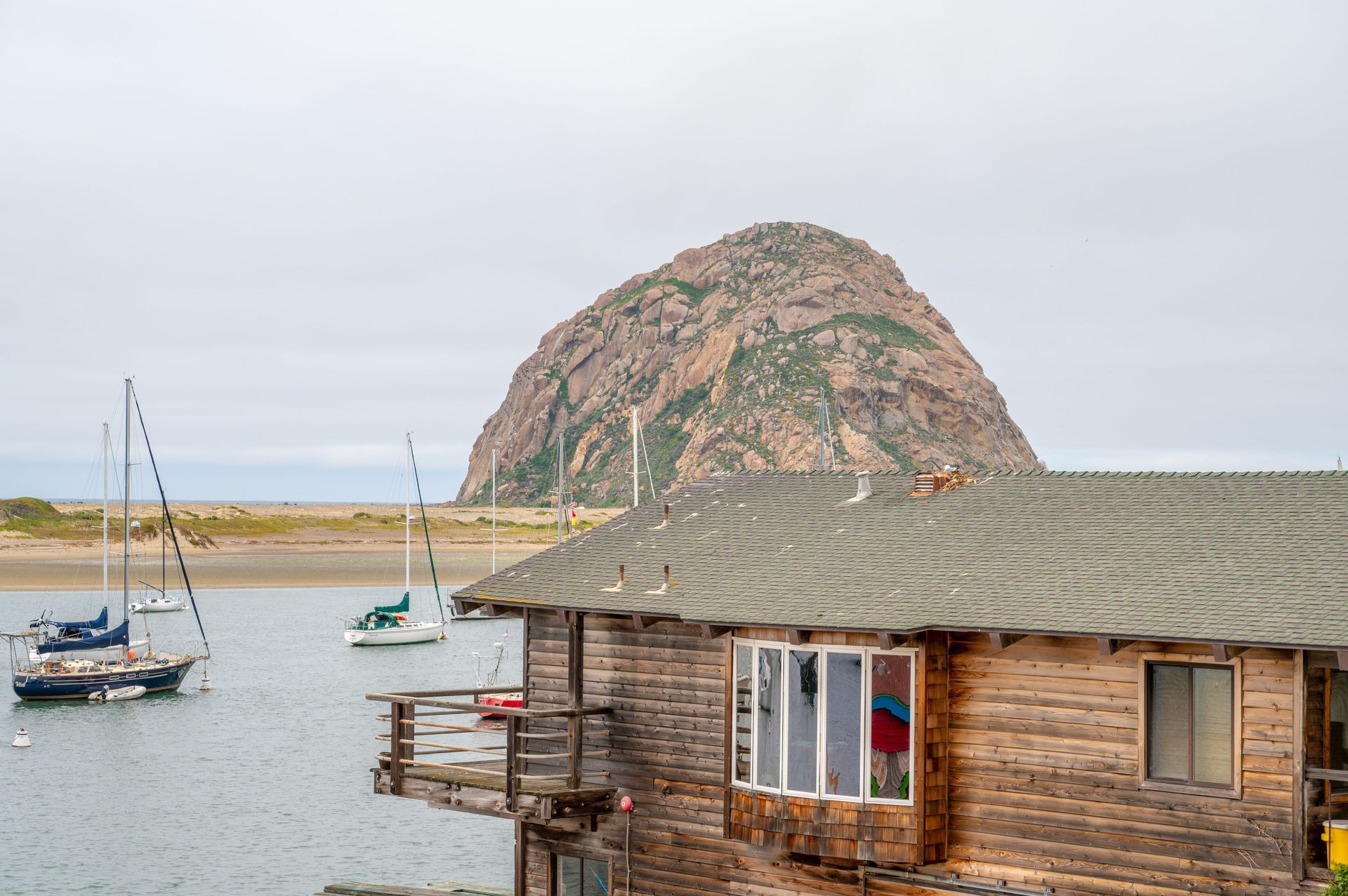 A small wooden house is sitting in the middle of a body of water.