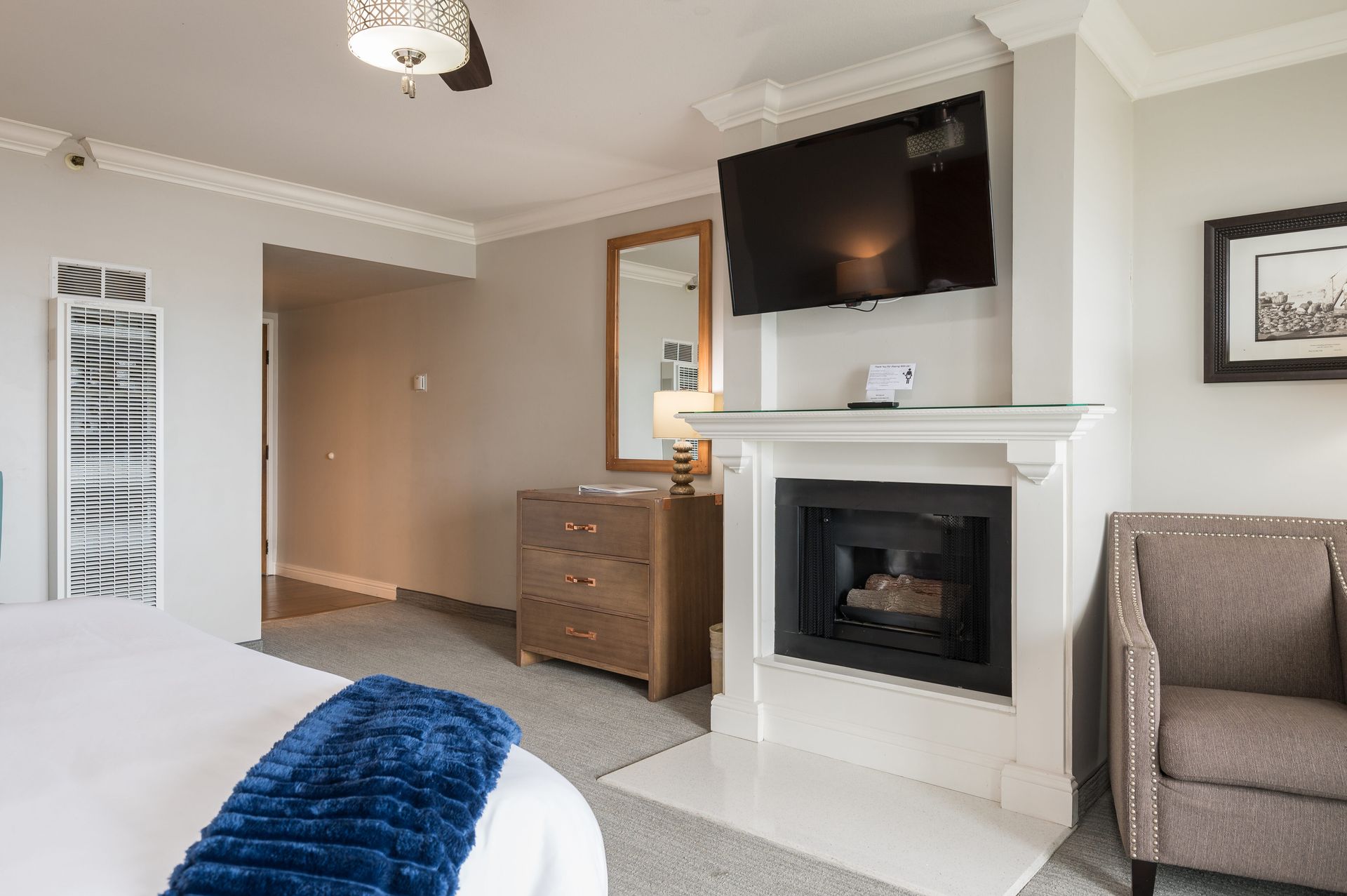 A hotel room with a fireplace and a flat screen tv.