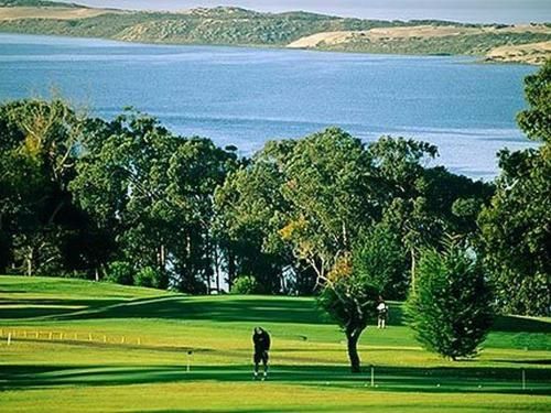 A golf course with a large body of water in the background