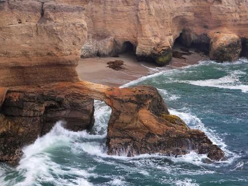 A cliff overlooking the ocean with waves crashing against it