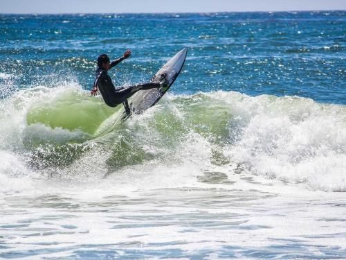 A person is riding a wave on a surfboard in the ocean.