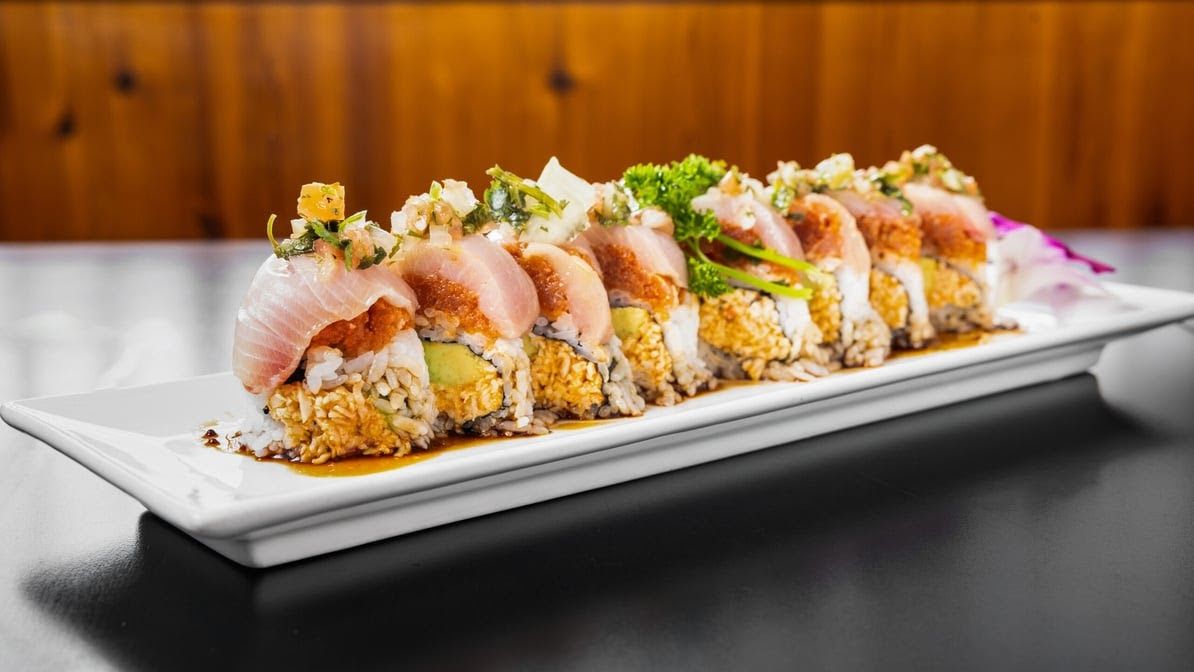 A white plate topped with sushi rolls on a table.