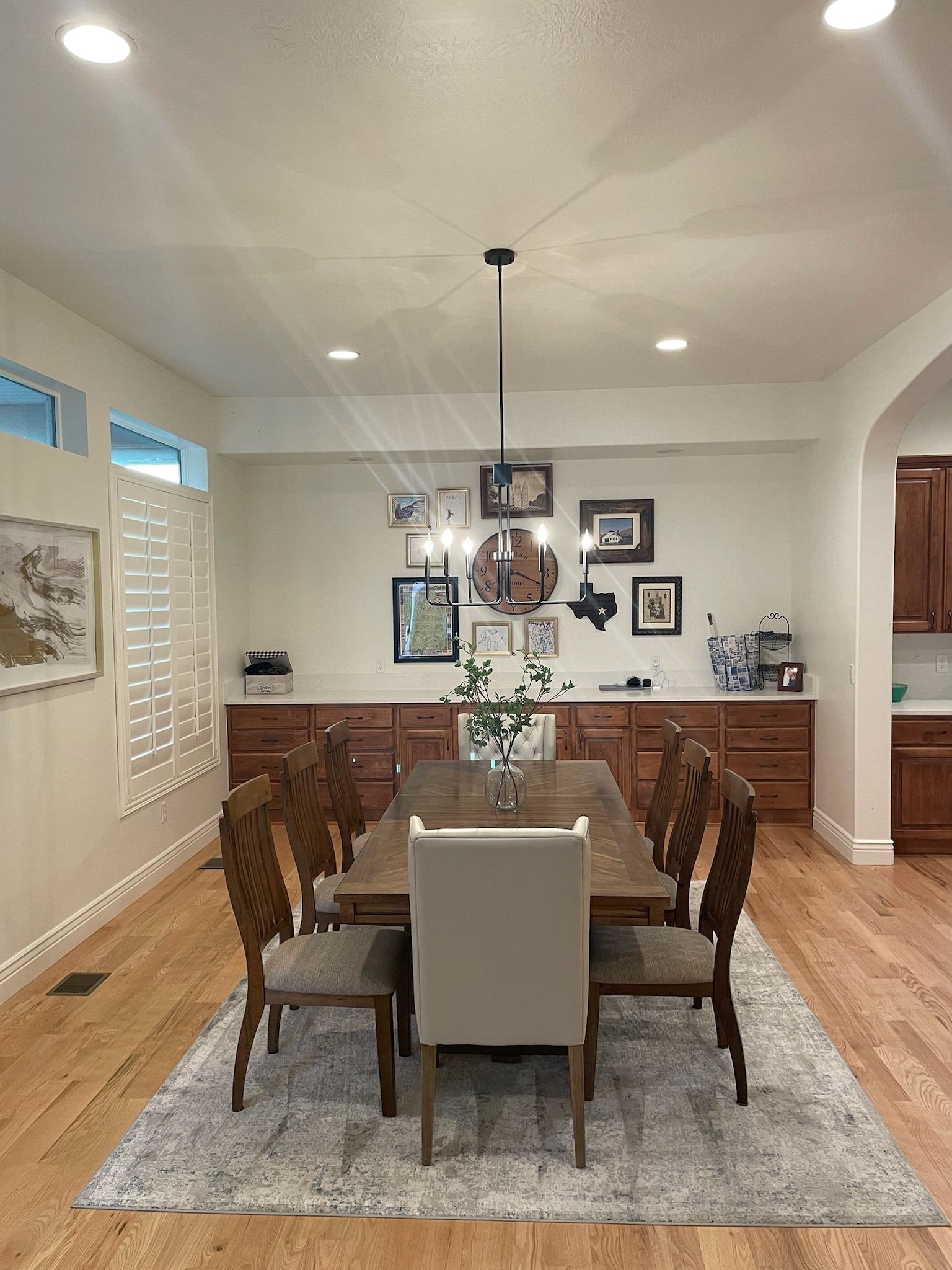 A dining room with a wooden table and chairs and a rug.