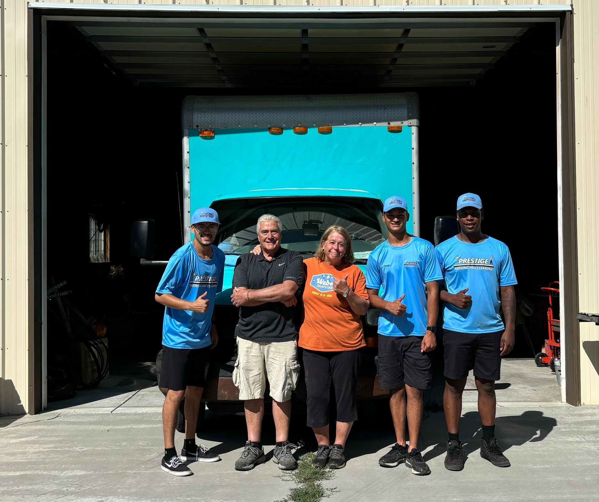 A group of people are posing for a picture in front of a truck.
