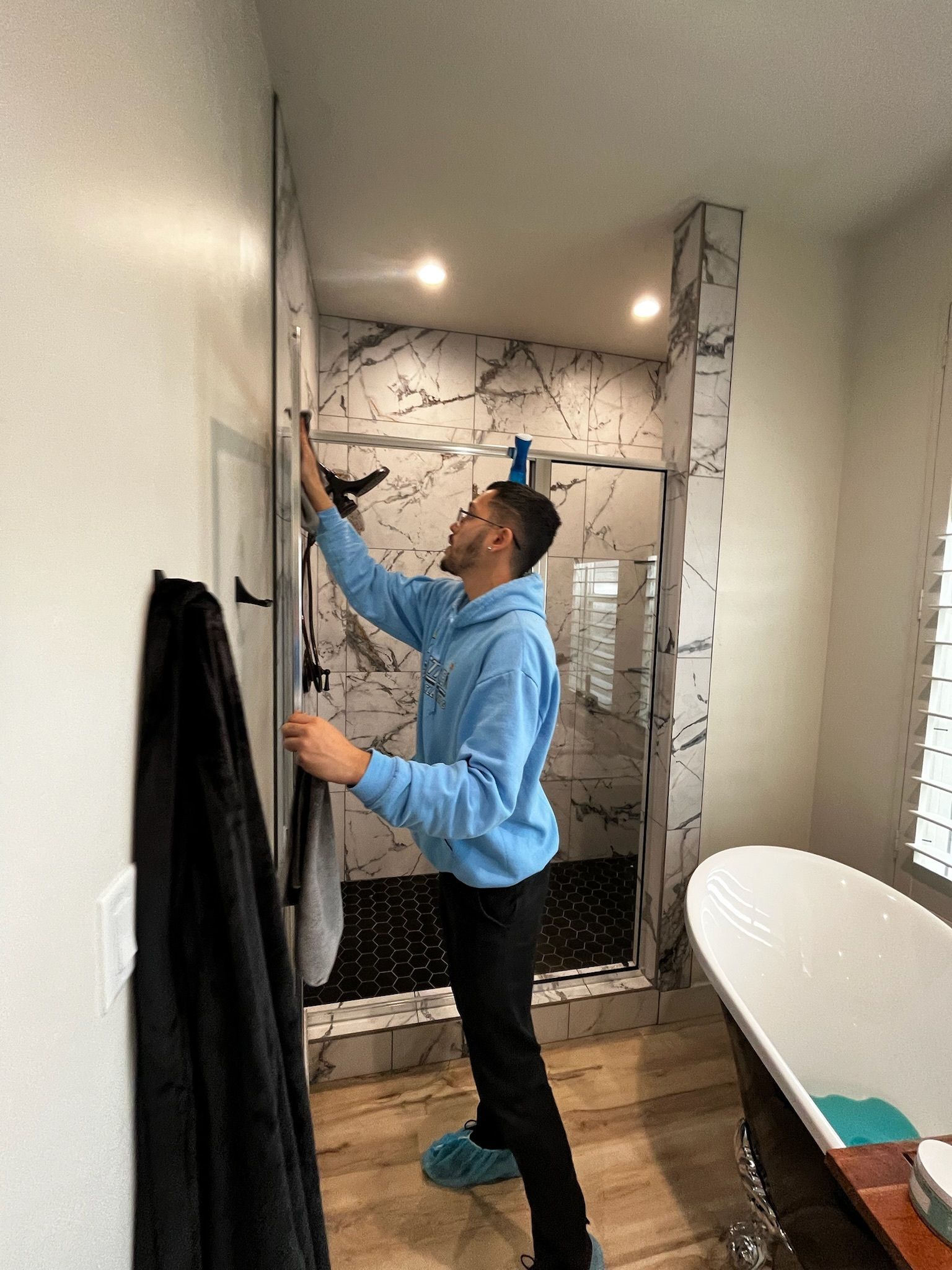 A man is standing in a bathroom holding a towel.