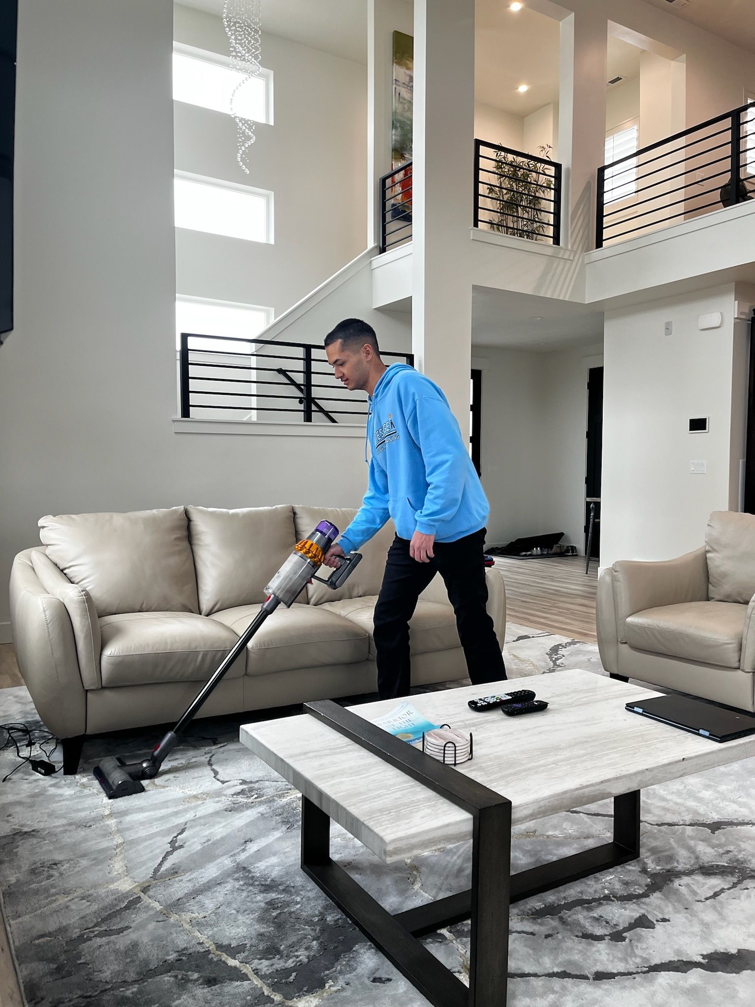 A man is using a vacuum cleaner in a living room.
