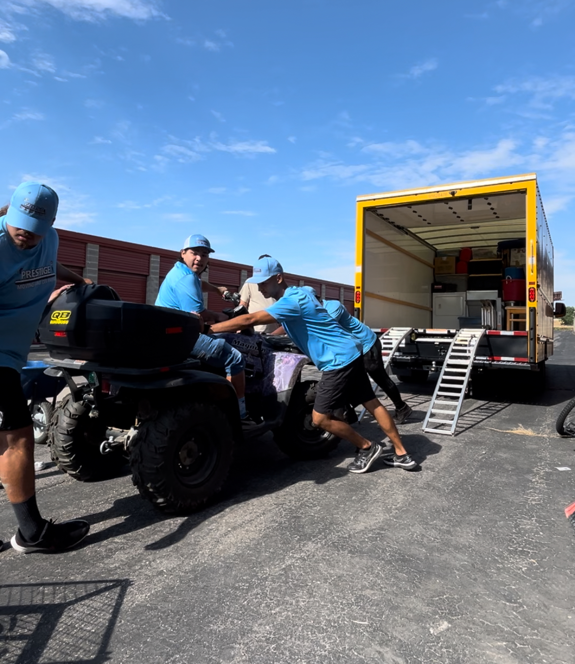 A group of men are pushing a motorcycle in front of a moving truck.