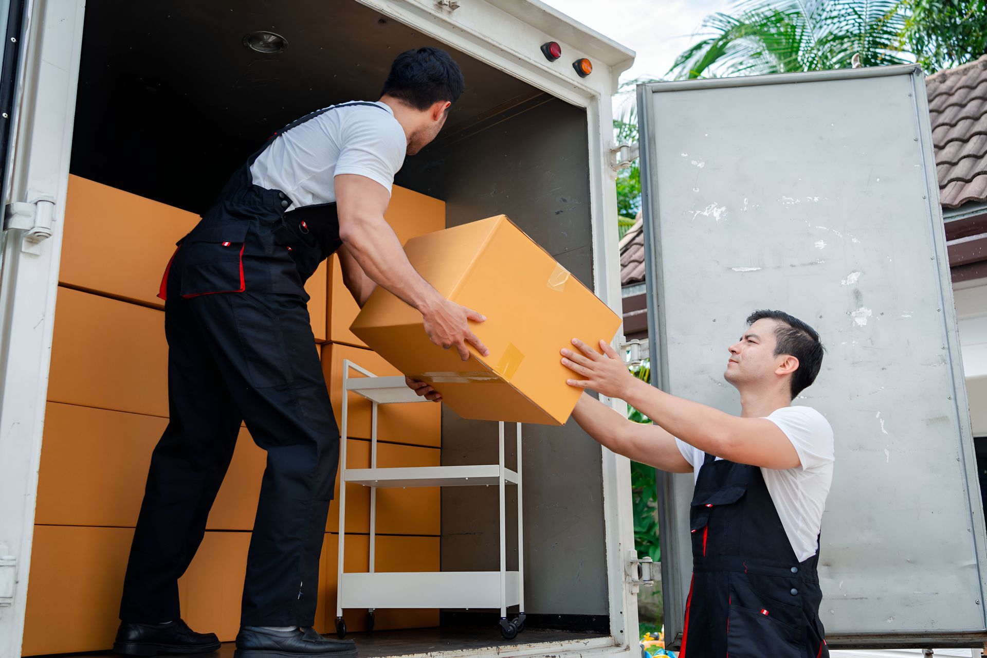 Two men are loading boxes into a truck.