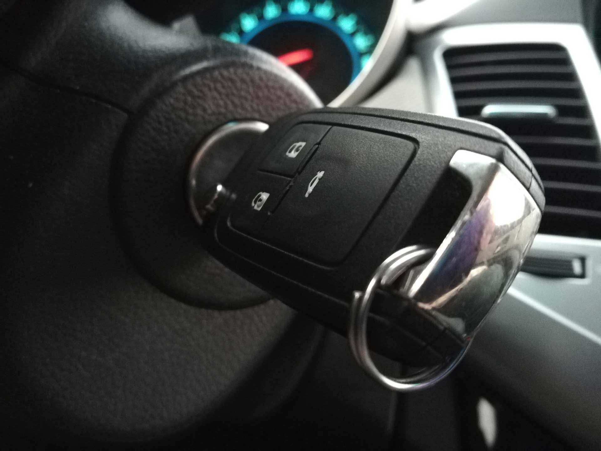 A close up of a car key on the steering wheel