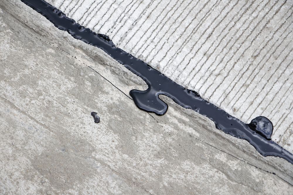 A close up of a concrete surface with a drip of liquid on it.