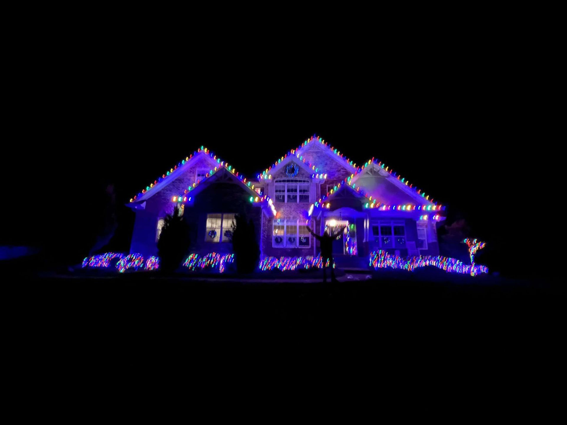 A house is decorated with christmas lights at night.