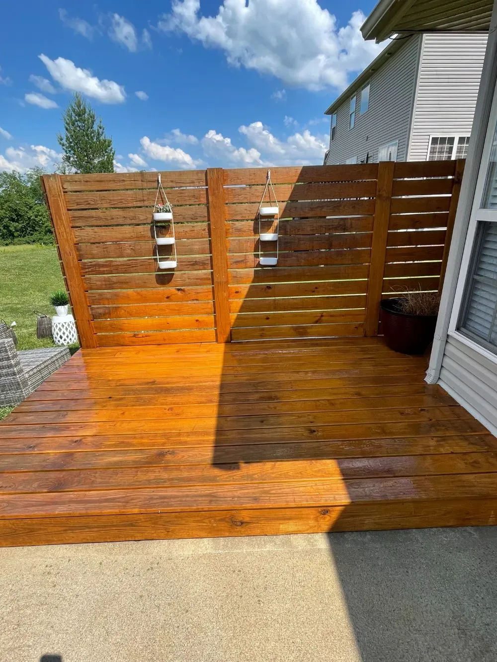 A wooden deck with a wooden fence surrounding it.